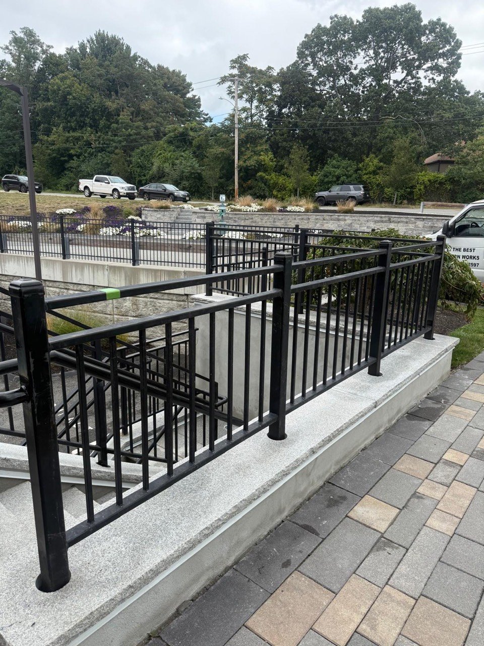 Black steel railing along a paved walkway