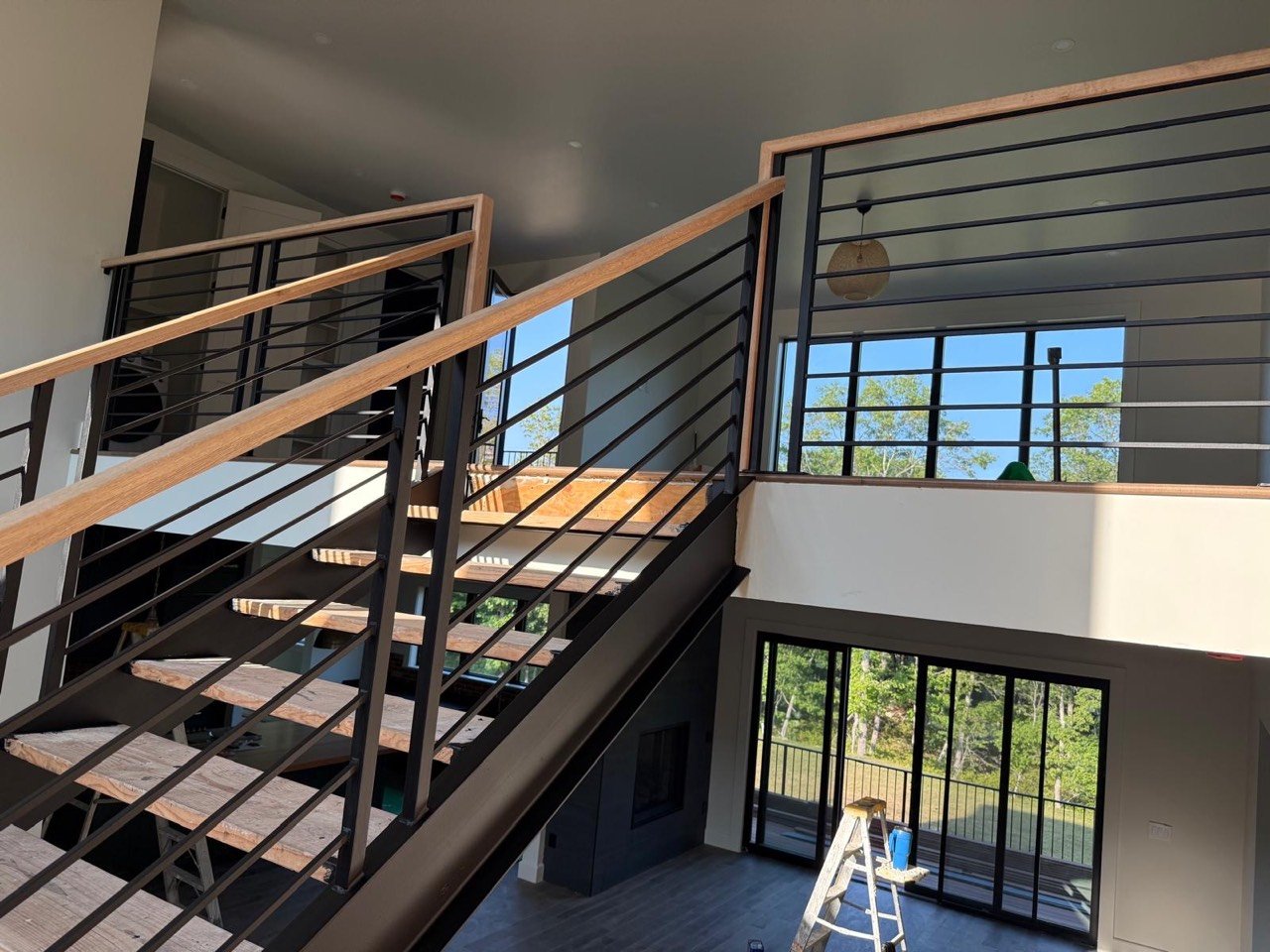 Black steel railing with wood handrail on an interior staircase